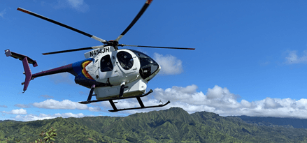 Jack Harter helicopter flying above lush mountains