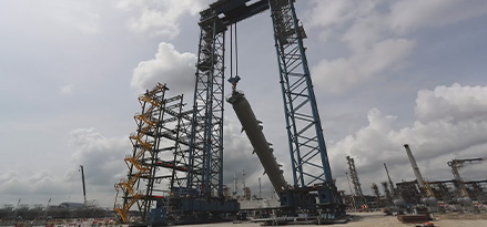 A new chemical reactor is hoisted into place at the Singapore Resid Upgrade Project site by a construction team.