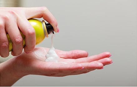 Female adding hair mousse to hand