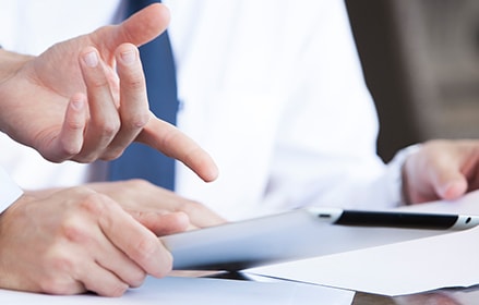 businessmen dicussing over pen and paper writing on documents