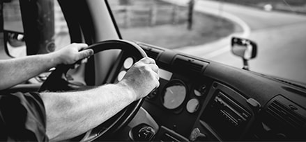 Man driving commercial vehicle on the road photo in black and white